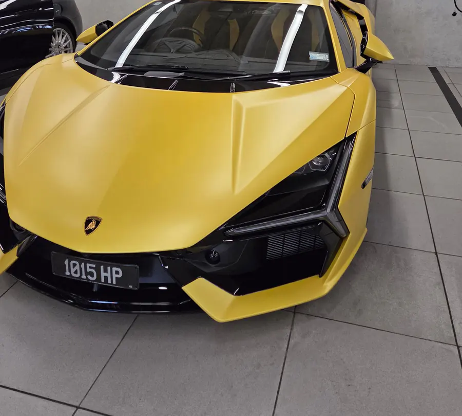 Matte yellow Lamborghini Revuelto — front three-quarter on the showroom floor